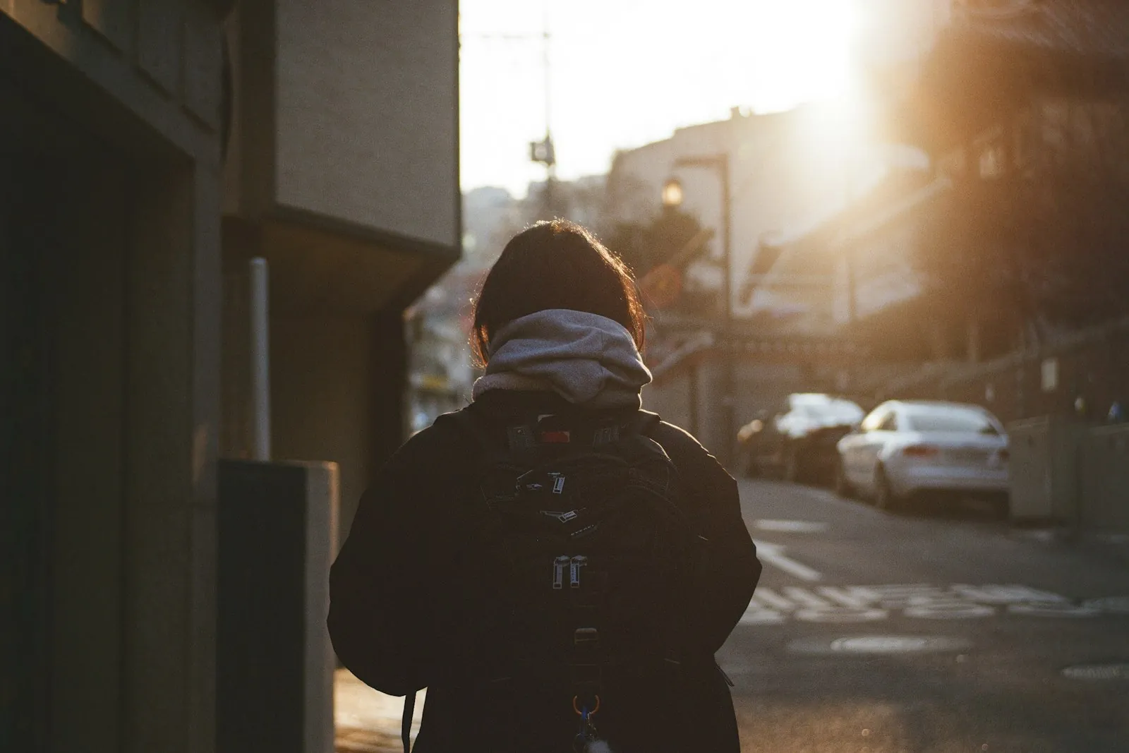 Foreigner with a backpack walking a Seoul street at sunset, setting up a Korea SIM card and Korean phone number
