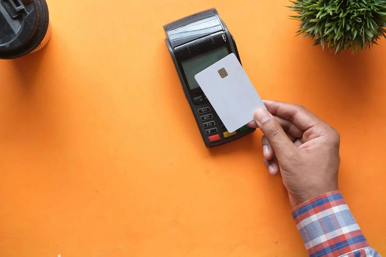 Hand making a card payment at a terminal, illustrating Korean banking and Kakao Pay verification for foreigners